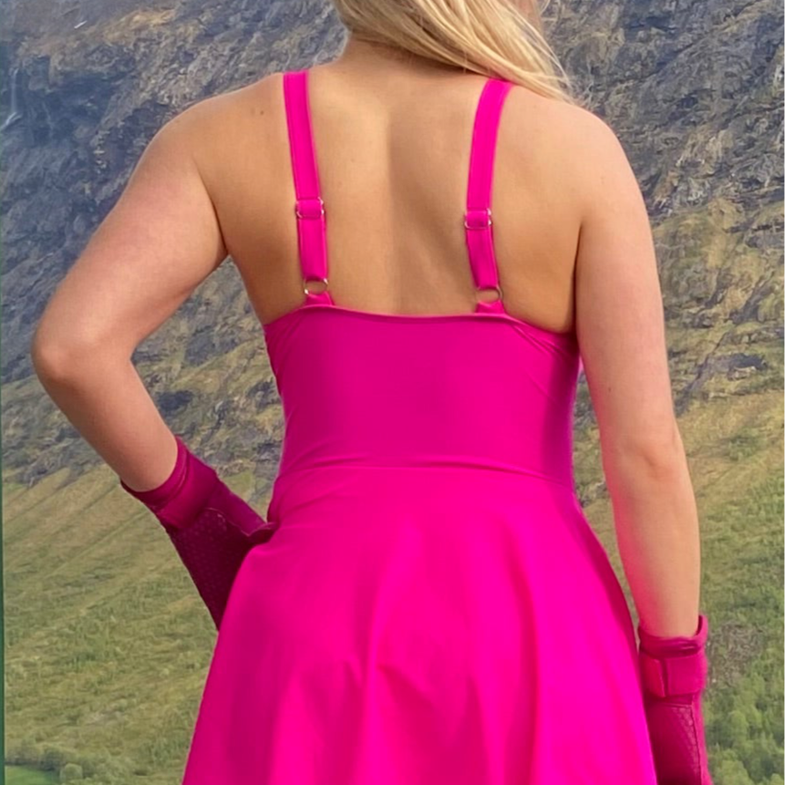 Marilyn badekjole i rosa , sett bakfra på en dame som har på rosa neopren hansker. Badekjolen har justerbare stropper